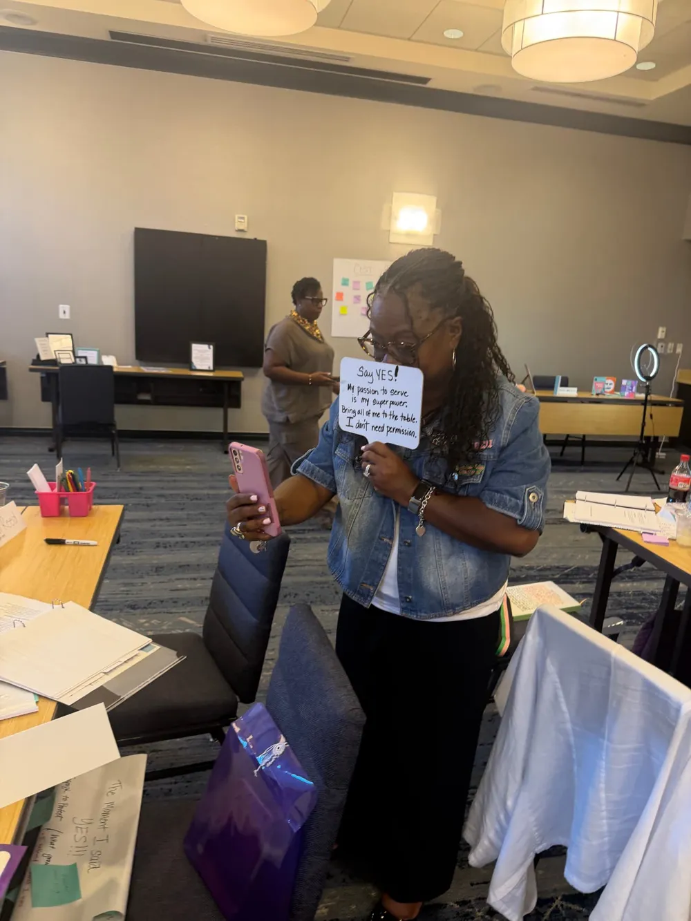 A participant holding a sign reading “Say YES! My passion to serve is my superpower”